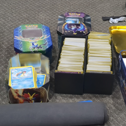 1200+ Pokemon TCG Card Lot w/ Storage Tins, etbs, a playing mat, & Deck Boxes - Image 1