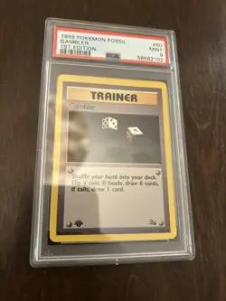 1999 POKEMON FOSSIL 1ST EDITION #60 - GAMBLER PSA 9 - Image 1
