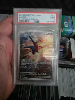 2024 Pokemon Surging Sparks Latios Illustration Rare (#203/191) in a PSA 9 Mint - Image 1