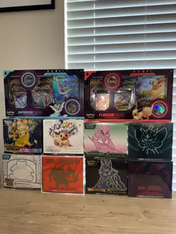 7 Pokemon Center ETB's + 1 ETB (Tear in Plastic) + 2 VMAX Boxes - Image 1