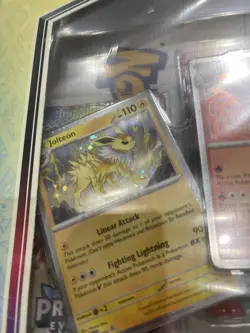 Pokemon TCG: Scarlet And Violet Prismatic Evolutions Poster Collection In Hand - Image 2
