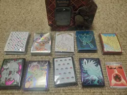 Pokemon Card Sleeve Lot featuring MEW, PRE, & more + EMPTY charizard tin - Image 1
