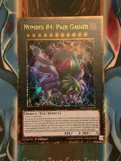 Yu-Gi-Oh Card - PGL3-EN010 - NUMBER 84: PAIN GAINER (gold secret rare holo) NM - Image 1
