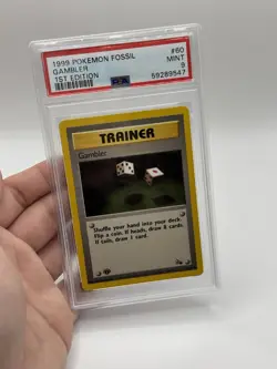1999 POKEMON FOSSIL 1ST ED#60 GAMBLER PSA 9 - Image 1