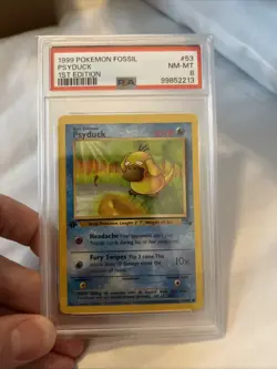 1999 Pokemon Fossil 1st Edition 53 Psyduck PSA 8 NM-MT - Image 1