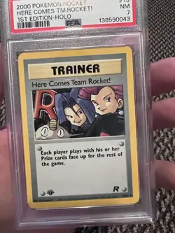 PSA 7 Pokemon 2000 Team Rocket ‘Here Comes Team Rocket!’ Holo 1st Ed #15 - Image 1