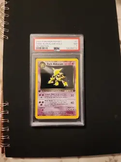 PSA 7 - 2000 POKEMON ROCKET #1 DARK ALAKAZAM-HOLO 1ST EDITION - Image 1