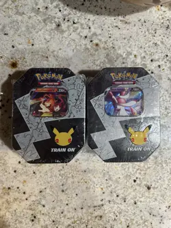 Pokemon 25th Anniversary Celebrations Tin Set: Lance's Charizard & Dark Sylveon - Image 1
