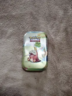 tin containing 40 cards ranging from trainers energy pokemon plus a sticker - Image 1