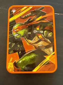 2026 MTG TEENAGE MUTANT NINJA TURTLES - Michelangelo Orange Booster Tin *Empty* - Image 1