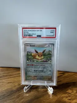 2024 POKEMON SSP EN #143 EEVEE REVERSE HOLO PSA 9 POP 25 SURGING SPARKS - Image 1