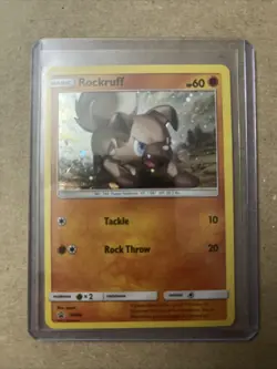 Rockruff SM06 Black Star Promo COSMOS Holo Pokemon Card LP 2017 Small Crease - Image 1