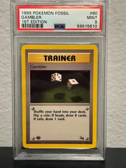 1999 POKEMON FOSSIL 1ST ED #60 GAMBLER PSA 9 - Image 1
