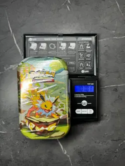 (VERY HEAVY)🔥 107.01g Pokemon Prismatic Evolutions Mini Tin Brand New Sealed - Image 1